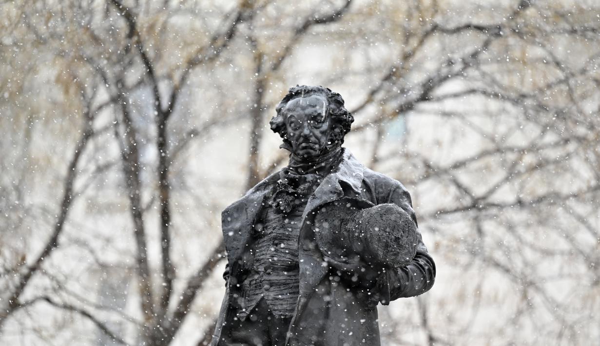 Hujan salju turun di atas patung pelukis Spanyol Francisco de Goya oleh pematung Mariano Benlliure di pusat kota Madrid (7/1/2021). Badan cuaca Aemet memperkirakan akan menjadi salah satu yang paling bersalju dalam beberapa tahun terakhir. (AFP/Gabriel Bouys)