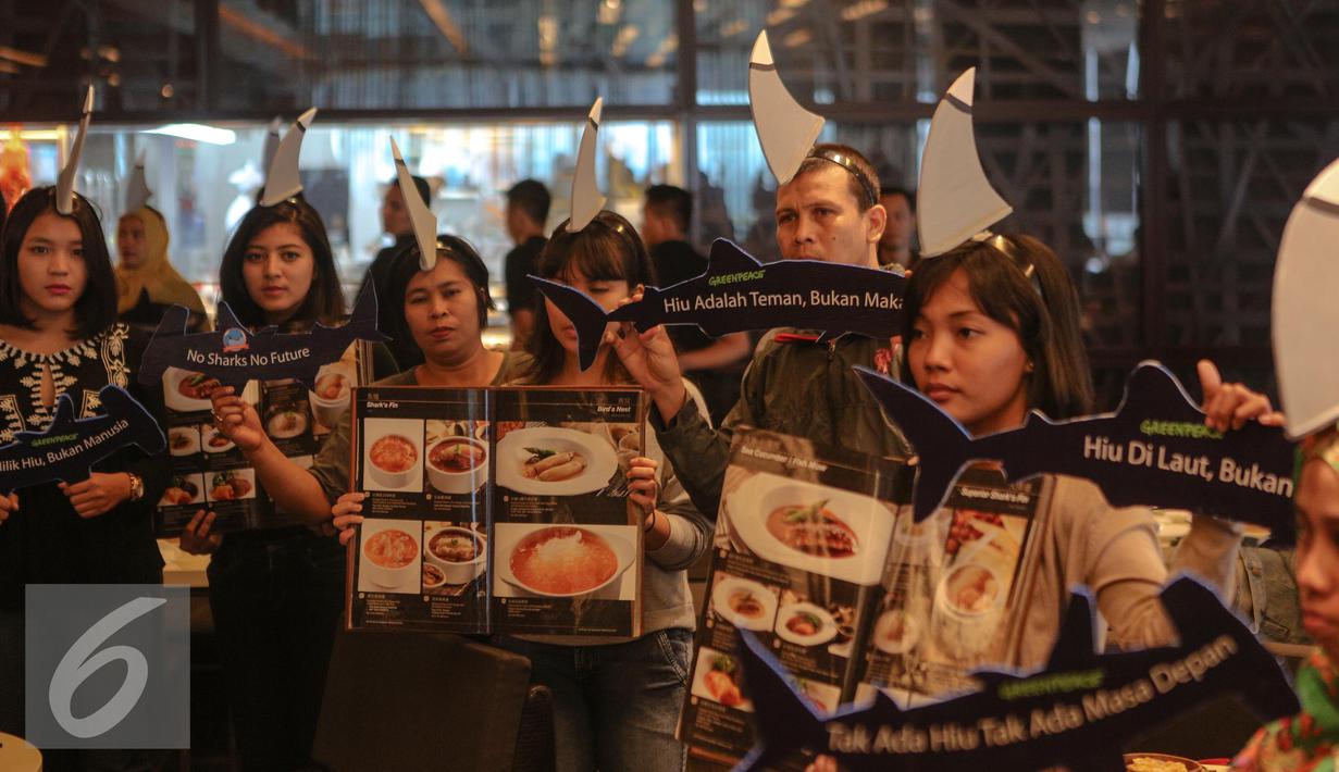 Sejumlah aktivis Greenpeace Indonesia menggelar kampanye selamatkan hiu (savesharks) di salah satu rumah makan, Jakarta, Minggu (12/7/2015). Aksi tersebut sebagai upaya menyelamatkan hiu dari kepunahan. (Liputan6.com/Faizal Fanani)