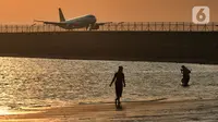 Wisatawan mengunjungi objek wisata Pantai Kelan dengan latar belakang pesawat yang mendarat di Tuban, Badung, Denpasar, Kamis (5/5/20222). Kunjungan wisatawan domestik (Wisdom) ke Pulau Bali, saat libur Lebaran Idul Fitri tahun 2022 terus meningkat. Per hari kedatangan wisdom rata-rata 40 ribu. (merdeka.com/Arie Basuki)