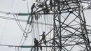 Pekerja menyelesaikan pekerjaan jaringan SUTET di Tangerang, Banten, Senin (2/1/2021). PT PLN (Persero) memiliki pasukan khusus yang terlatih melakukan pemeliharaan, perbaikan, dan penggantian perangkat isolator, konduktor maupun komponen lainnya pada jaringan listrik. (Liputan6.com/Angga Yuniar)