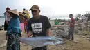 Warga membawa ikan di kawasan Pasar Sumur Jaya, Pandeglang, Banten, Sabtu (3/8/2019). Hingga saat ini tidak ada kerusakan yang berarti di kawasan Kecamatan Sumur usai gempa bermagnitudo 6,9 mengguncang Banten. (merdeka.com/Arie Basuki)