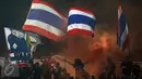 Suporter Timnas Thailand menyalakan suar saat menyambut kemenangan timnya atas Indonesia di National Stadium Rajamangala, Bangkok, Sabtu (17/12). Thailand berhasil meraih piala AFF untuk yang kelima kali. (Liputan6.com/Helmi Fithriansyah)