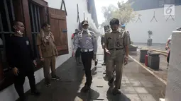 Gubernur DKI Jakarta Anies Baswedan saat meninjau lokasi kebakaran Museum Bahari, di Jalan Pasar Ikan, Penjaringan, Jakarta Utara, Selasa (16/1). Anies datang menggenakan pakaian Dishub ditemani pejabat Pemprov DKI Jakarta. (Liputan6.com/Arya Manggala)
