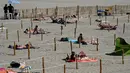 Orang-orang berjemur menikmati matahari di Sunset Beach dengan area terpisah untuk mematuhi jaga jarak di La Grande-Motte, Prancis, Selasa (26/5/2020). Ukuran area pemisah berupa kotak ini pun beragam yang dapat ditempati oleh dua, empat, atau enam orang. (Pascal GUYOT/AFP)