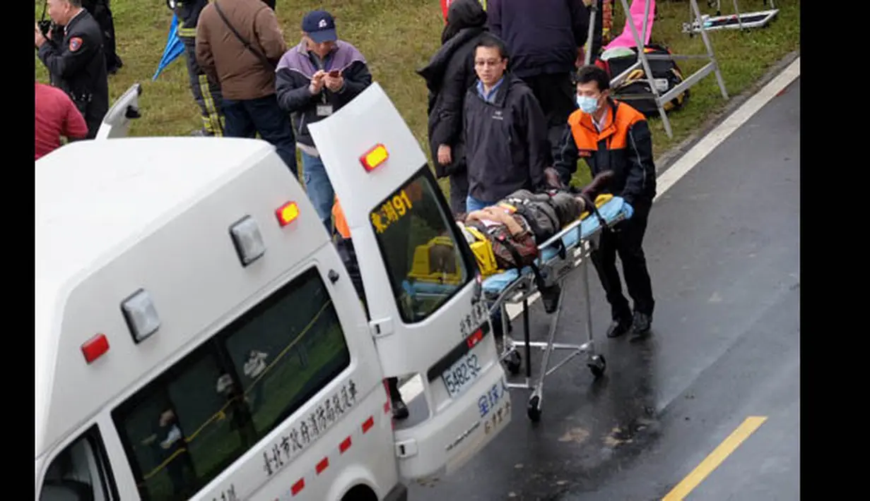 Tim penyelamat mengevakuasi penumpang pesawat turboprop ATR 72-600 TransAsia ke dalam ambulans di pinggir Sungai Taipei, Taiwan, Rabu (4/2/2015). Pesawat turboprop ATR 72-600 TransAsia terhempas ke Sungai Taipei. (AFP PHOTO/Sam Yeh)