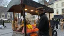 Seorang pedagang kaki lima menjual permen di shopping street di Ghent, Belgia, Rabu (22/12/2021). Belgia memutuskan untuk lebih memperketat pembatasan guna mengantisipasi varian Omicron yang melonjak tetapi menghindari lockdown penuh seperti yang dilakukan Belanda. (AP Photo/Virginia Mayo)