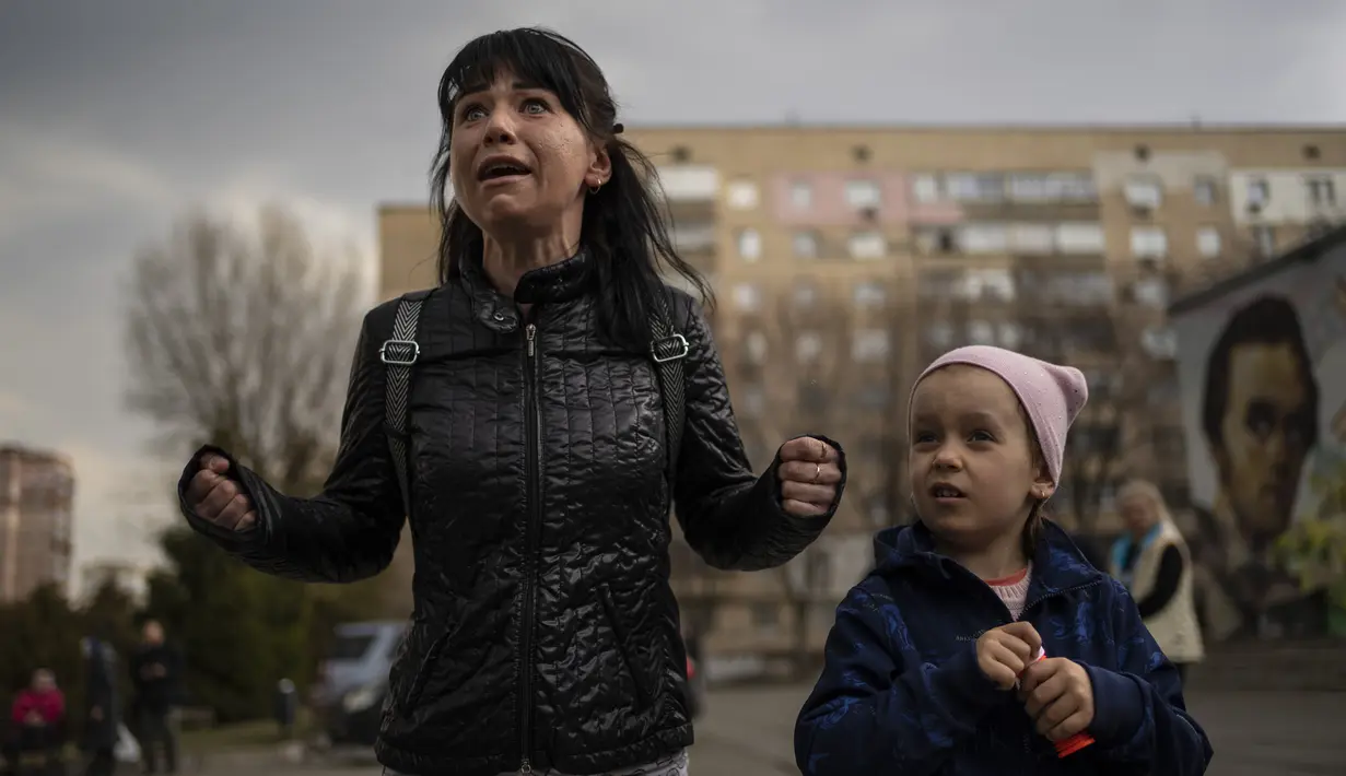 Julia, 34, menangis di samping putrinya Veronika, 6, saat berbicara dengan sekelompok wartawan di Brovary, di pinggiran Kyiv, Ukraina, Selasa, 29 Maret 2022. Invasi Rusia ke Ukraina yang dimulai pada 24 Feberuari 2022 masih berlangsung hingga hari ini. (AP Photo/Rodrigo Abd)