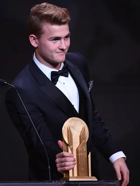 Pemain Juventus Matthijs de Ligt menunjukkan piala Kopa Trophy pada malam penghargaan Ballon d'Or 2019 di Chatelet Theatre, Paris, Prancis, Senin (2/12/2019). De Ligt dinobatkan sebagai pemain muda U21 terbaik di dunia. (FRANCK FIFE/AFP)