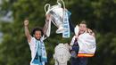 Pemain Real Madrid, Sergio Ramos dan Marcelo, mengangkat trofi Liga Champions di Monumen Cibeles, Madrid, Minggu (27/5/2018). Real Madrid menggelar pawai kemenangan bersama fans usai menjuarai Liga Champions 2018. (AP/Francisco Seco)