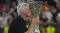 Pemain AS Roma, Jose Mourinho mencium trofi UEFA Europa Conference League setelah memenangkan laga final melawan Feyenoord di Air Albania Stadium, Tirana, Albania, 25 Mei 2022. (AFP/Ozan Kose)