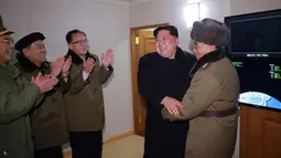 Pemimpin Korea Utara Kim Jong Un tertawa bersama sejumlah orang berseragam militer saat rudal balistik antar benua berhasil diluncurkan di di sebuah ruangan di Korea Utara (29/11). (KCNA/Korea News Service via AP)