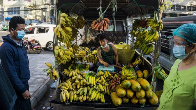 Seorang pria menjual pisang dari truk di sebuah pasar sehari setelah militer Myanmar merebut kekuasaan, Yangon, Myanmar, Selasa (2/2/2021). Militer Myanmar menahan pemimpin yang terpilih secara demokratis Aung San Suu Kyi dan memberlakukan keadaan darurat satu tahun. (STR/AFP)