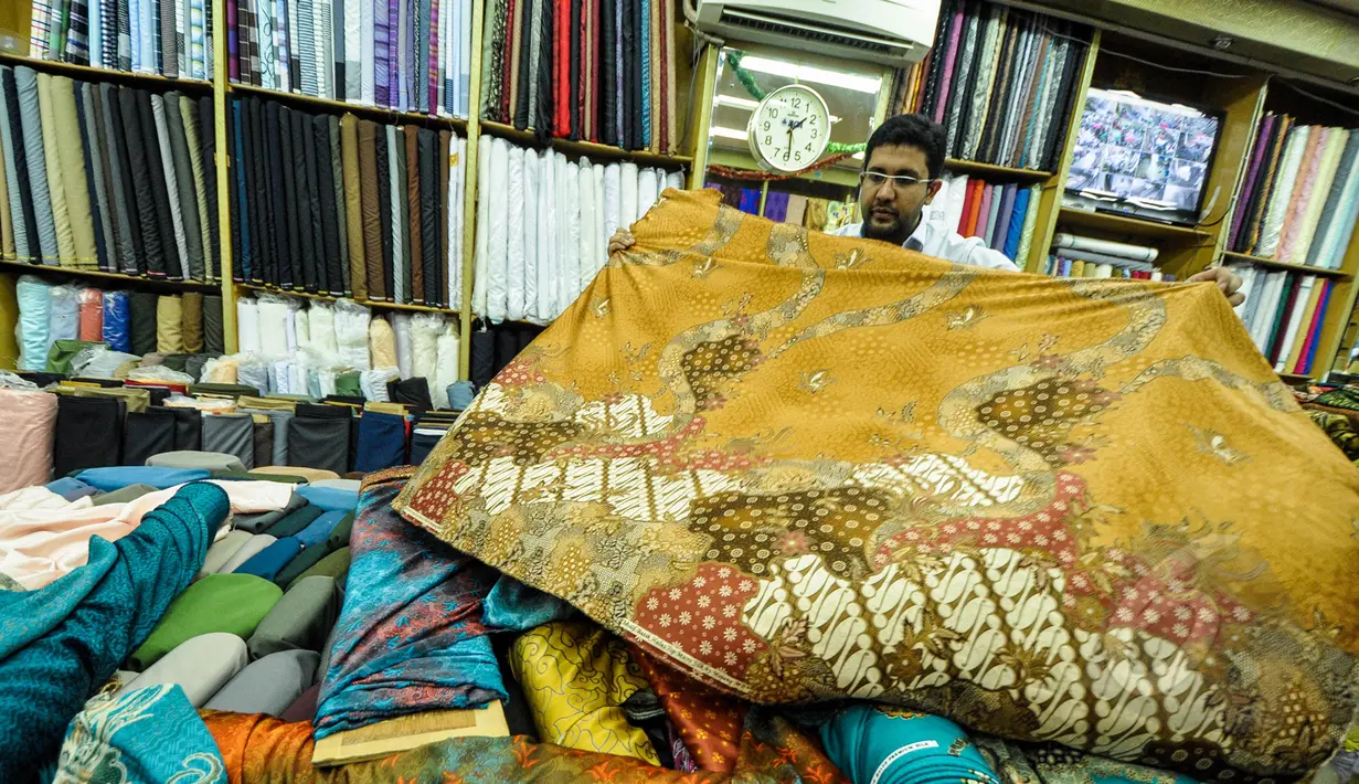Pekerja merapikan kain lokal di Pasar Baru, Jakarta, Selasa (24/3/2015). Pengusaha tekstil nasional meminta Presiden Jokowi untuk melakukan kerja sama dengan Uni Eropa dan Turki agar bisa meningkatkan ekspor tekstil nasional.(Liputan6.com/Faizal Fanani)