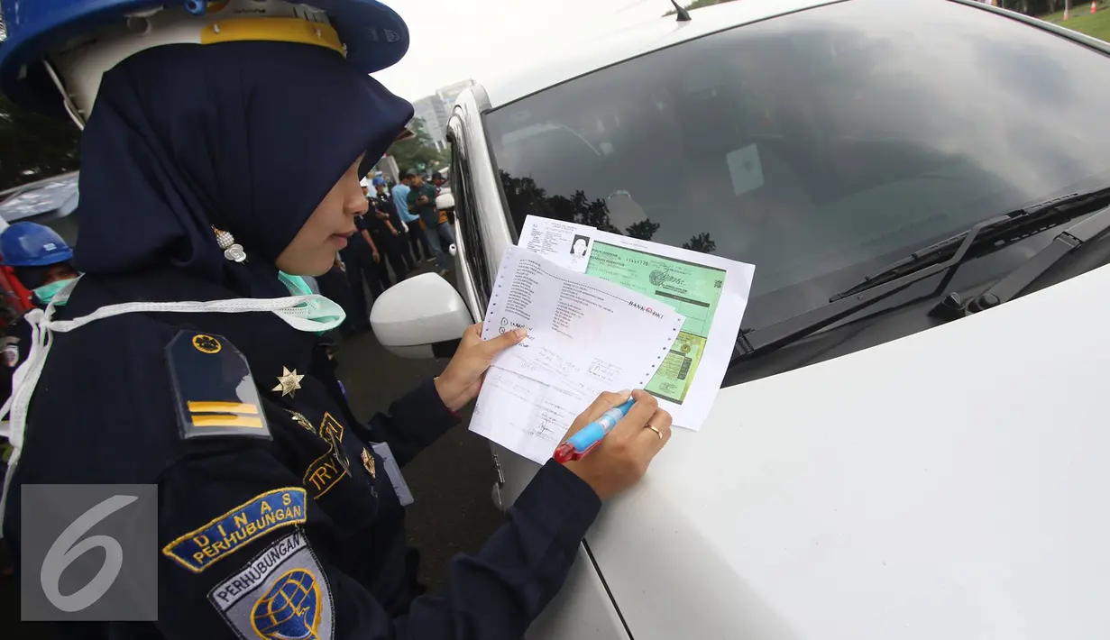 Petugas mendata mobil peserta saat tes uji SIM dan kir transportasi online di Jakarta, Senin (15/8). Kegiatan diadakan menyambut HUT Kemerdekaan RI ke-71 serta menciptakan layanan angkutan umum yang prima dan accountable. (Liputan6.com/Immanuel Antonius)