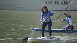 Menteri Kelautan dan Perikanan, Susi Pudjiastuti, mendayung saat bermain paddle board di Danau Sunter, Jakarta, Minggu (25/2/2018). Kegiatan ini dilakukan dalam rangka Festival Danau Sunter. (Bola.com/Okie Prabhowo)