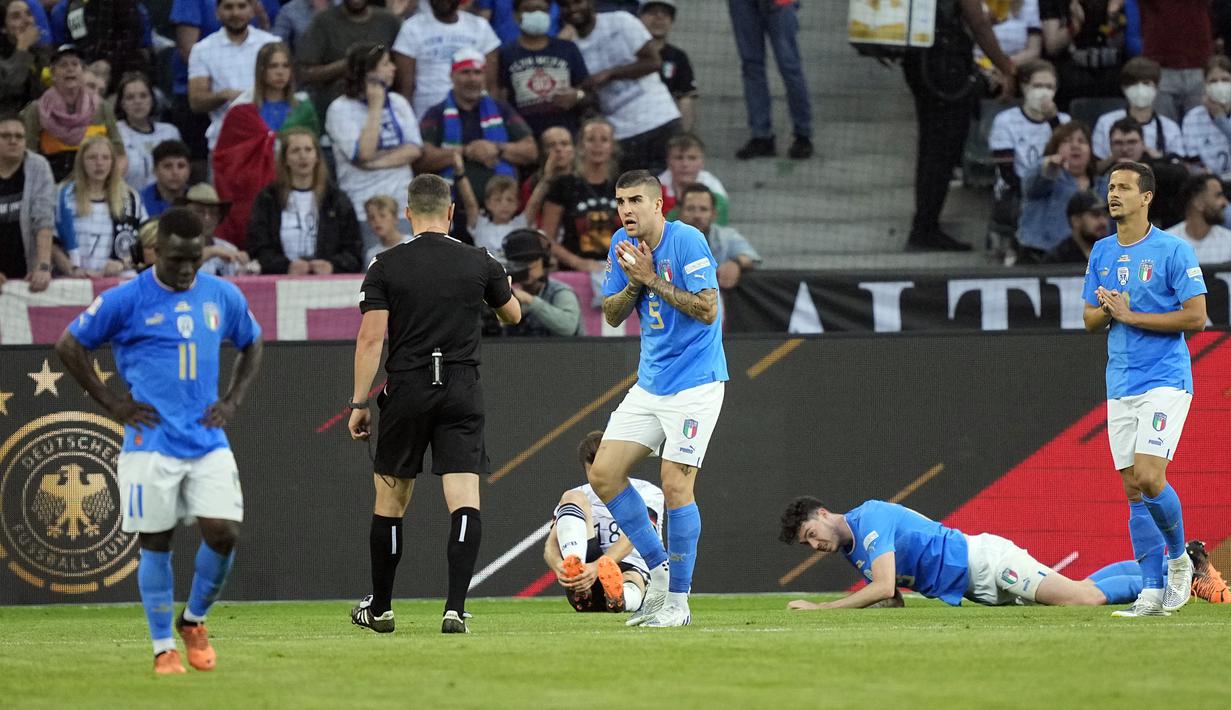 Pemain Italia Gianluca Mancini (tengah) berbicara dengan wasit setelah dia memberikan tendangan penalti untuk Jerman pada pertandingan sepak bola UEFA Nations League di Moenchengladbach, Jerman, 14 Juni 2022. Jerman mengalahkan Italia 5-2. (AP Photo/Martin Meissner)