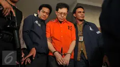 Buronan ‎kasus korupsi dana nasabah Bank Century, Hartawan Aluwi dikawal petugas keluar Bareskrim Mabes Polri, Jakarta, Jumat (22/4). Dengan pengawalan ketat anggota bersenjata laras panjang, Hartawan digelandang ke Kejagung. (Liputan6.com/Gempur M Surya)
