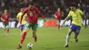 Pemain Maroko, Youssef En-Nesyr, berusaha melewati pemain Brasil, Ibanez, pada laga uji coba FIFA Matchday di Grand Stade de Tanger, Tangier, Minggu (26/3/2023). (AP Photo/Mosa'ab Elshamy)