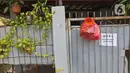 Bantuan bahan pokok kepada pasien positif Covid-19 yang melakukan isolasi mandiri di rumahnya terlihat di pagar di RT03/RW03, Kelurahan Cilangkap, Jakarta, Jumat (21/5/2021). (Liputan6.com/Herman Zakharia)