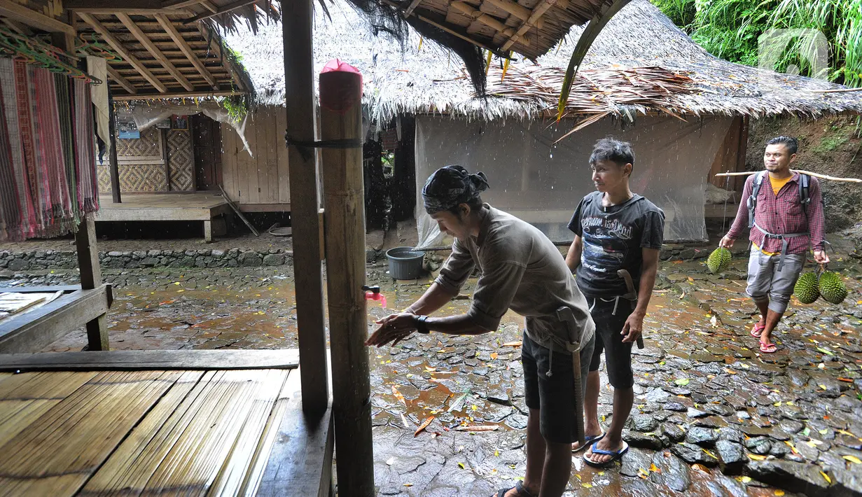 Warga adat setempat yang kembali dari ladang beberapa mampir membasuh tangan mereka pada air bambu tersebut. (merdeka.com/Arie Basuki)