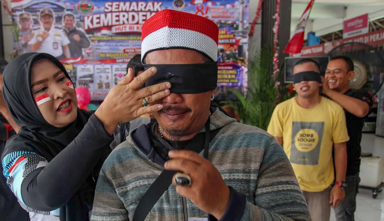 Warga yang tergabung dalam Paguyuban Terminal Bus Kampung Rambutan mengikuti lomba baris berbaris mata tertutup  jelang  peringatan HUT ke-81 Kemerdekaan Republik Indonesia di Terminal Kampung Rambutan, Jakarta, Rabu, 12 Agustus 2026. (KLY/Arie Basuki)