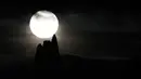 Bulan purnama yang dikenal sebagai Harvest moon muncul di atas Whitby Abbey, di Whitby, Inggris, Senin (20/9/2021). Bulan purnama Harvest Moon biasanya terjadi di bulan September, namun kadang juga terlambat hingga ke Oktober. (AP Photo/Alastair Grant)