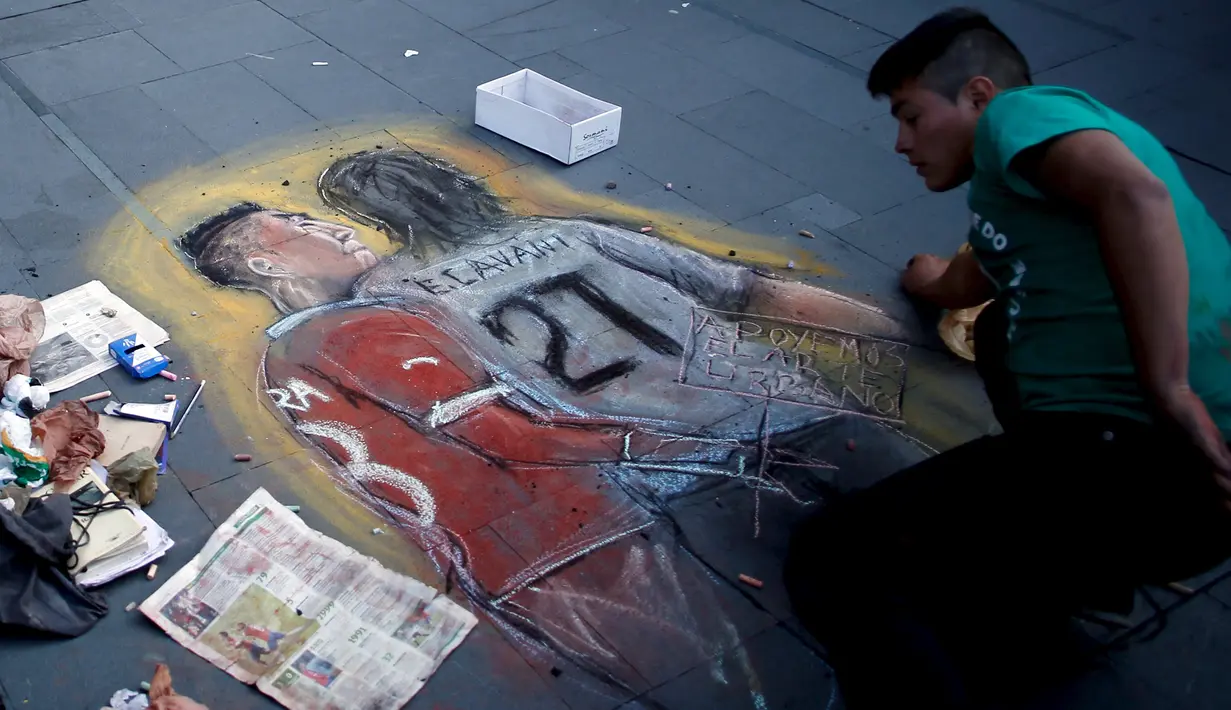 Seniman Chili melukis tindakan provokasi Gonzalo Jara terhadap pemain Uruguay, Edinson Cavani di trotoar jalan di Santiago, Chili (28/6/2015). Konfederasi Sepak Bola Amerika Selatan menghukum Gonzalo Jara bermain di tiga laga. (REUTERS/Marcos Brindicci)