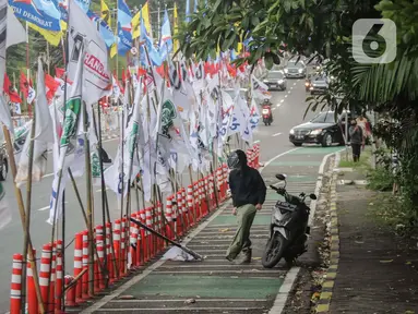 Ratusan bendera parpol terpasang di tiang plastik pembatas jalur sepeda (stick cone) di Jalan Rasuna Said, Jakarta, Senin (8/1/2024). (Liputan6.com/Angga Yuniar)