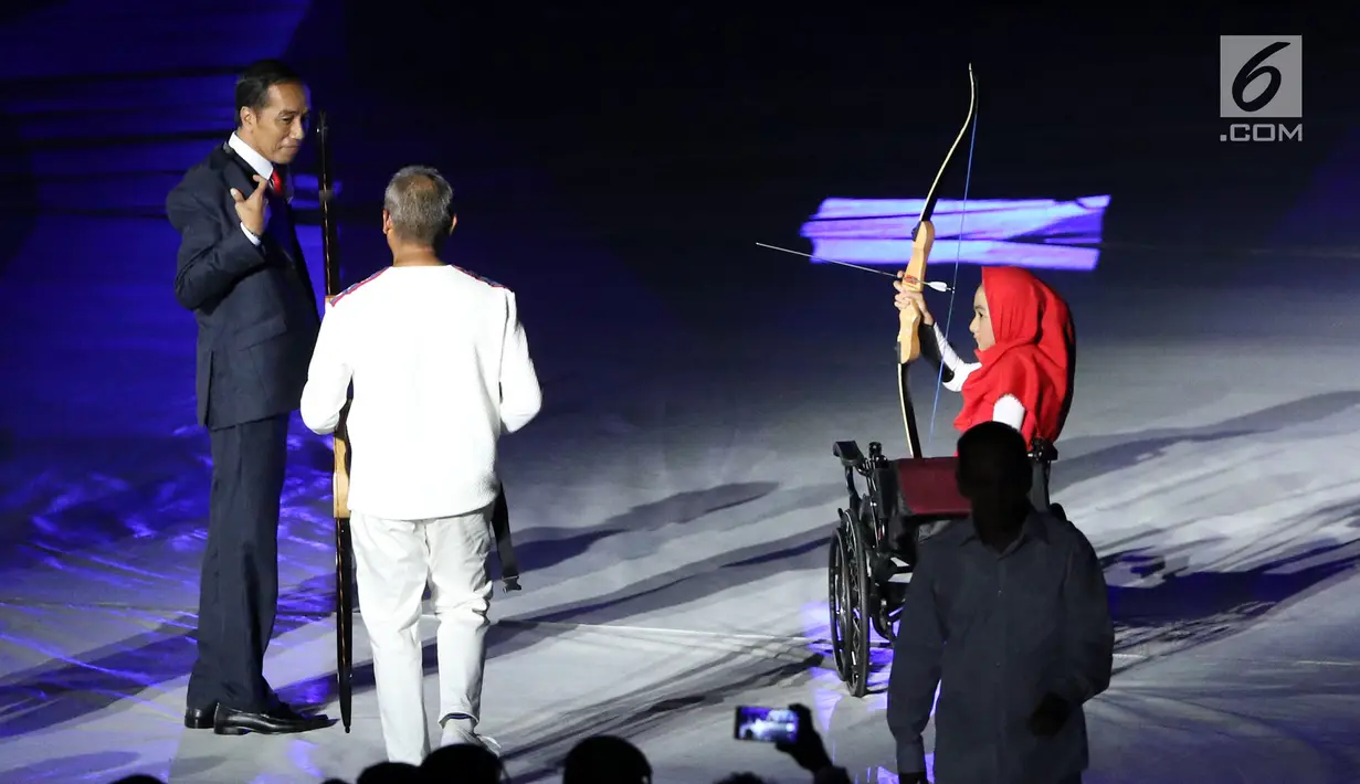 Presiden RI, Joko Widodo (tengah) bersiap memanah tugu bersama penyandang disabilitas saat malam pembukaan Asian Para Games 2018 di SUGBK, Jakarta, Sabtu (6/10).  Asian Para Games 2018 berlangsung 6-13 Oktober. (Liputan6.com/Helmi Fithriansyah)