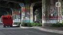 Pengendara truk melintasi sisi tiang penyangga Jalan Tol Pelabuhan Lingkar Dalam Jakarta di Jalan Ancol Timur, Jakarta, Selasa (16/6/2020). Seni mural yang dulu menghiasi tiang-tiang jalan tol di kawasan tersebut kini terlihat kusam dan berdebu. (Liputan6.com/Helmi Fithriansyah)