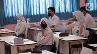 Siswa mengikuti uji coba pembelajaran tatap muka (PTM) terbatas di SMAN 1 Kota Tangerang, Banten, Senin (6/9/2021). Dinas Pendidikan Provinsi Banten uji coba PTM di SMA di Kota Tangerang secara terbatas dengan sistem bergiliran serta menerapkan protokol kesehatan ketat. (Liputan6.com/Angga Yuniar)