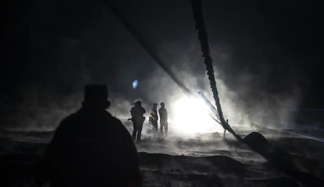 Warga dan tim penyelamat memeriksa area yang tertutup abu vulkanik dalam upaya mencari korban atau jenazah pasca erupsi Gunung Semeru di Desa Sumber Wuluh, Lumajang, Minggu (5/12/2021). (AFP/Juni Kriswanto)