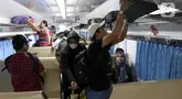Penumpang menaikkan barang bawaan di dalam gerbong Kereta Api Jarak Jauh (KAJJ) di Stasiun Pasar Senen, Jakarta, Rabu (26/3/2025). (Liputan6.com/Herman Zakharia)