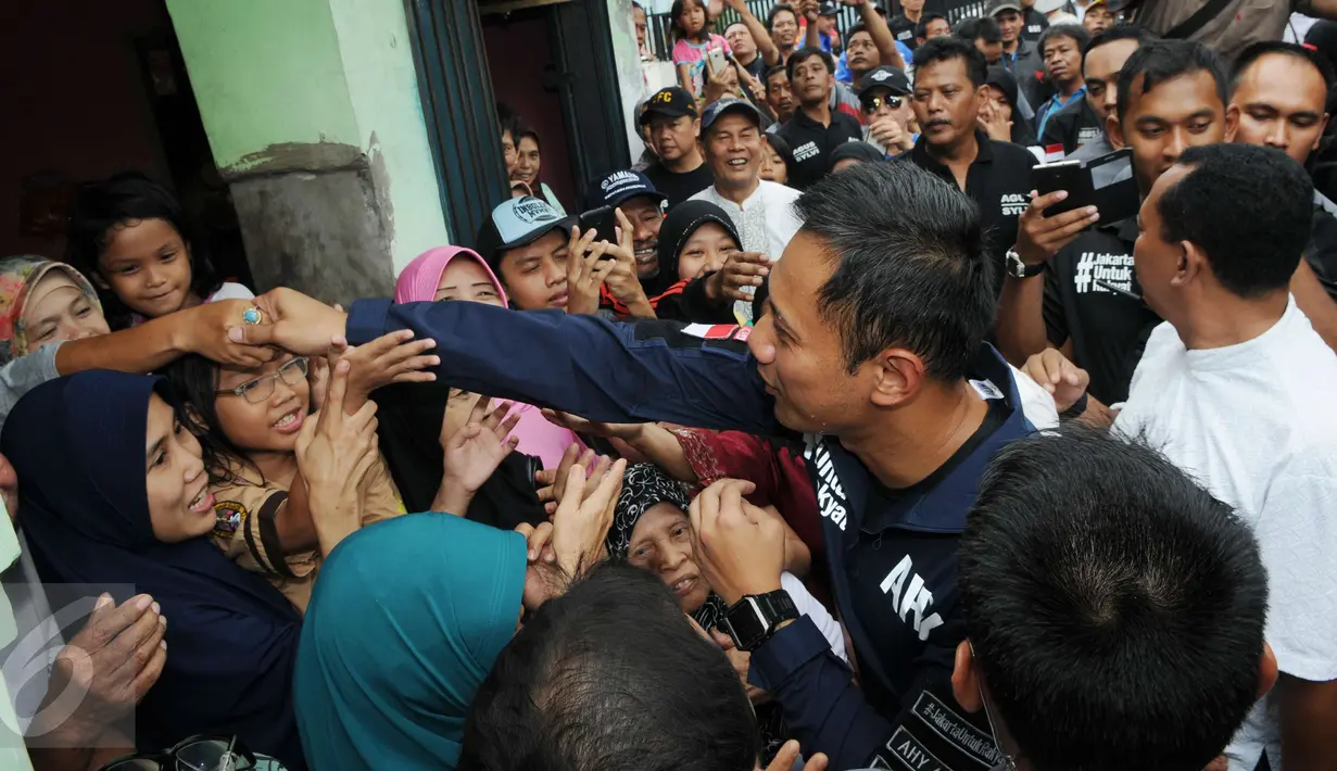 Sejumlah warga berebut untuk bersalaman dengan Cagub DKI Jakarta Agus Harimurti Yudhoyono saat mengunjungi perkampungan Tegal Parang, Jakarta, Selasa (7/12). AHY dicurhati warga sekitar seputar penyelesaian masalah banjir. (Liputan6.com/Helmi Afandi)