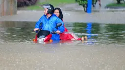 Pesepeda motor mencoba menerobos jalanan yang banjir di Jiujiang , Provinsi Jiangxi , Cina , (19/2). Hujan lebat terus-menerus membuat kawasan Kota Jiujiang banjir dan melumpuhkan lalu lintas. (REUTERS/ China Daily)