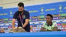 Seorang ofisial tim mengambil seekor kucing untuk diturunkan dari meja konferensi pers saat penyerang  Brasil Vinicius Junior berbicara pada sesi tanya jawab jelang Kroasia vs Brasil pada perempat final Piala Dunia 2022, di Stadion Al Arabi SC di Doha, Rabu (7/12/2022).  Kejadian ini diprediksi akan menjadi meme dan viral di media sosial. (NELSON ALMEIDA / AFP)