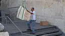 Pekerja Otoritas Pengurus Benda Antik Israel berusaha memindahkan batu besar yang jatuh dari Tembok Ratapan di Kota Tua Yerusalem, Rabu (25/7). Batu di atas bagian utama Tembok Ratapan diperiksa oleh para profesional dua kali setahun. (AFP/AHMAD GHARABLI)
