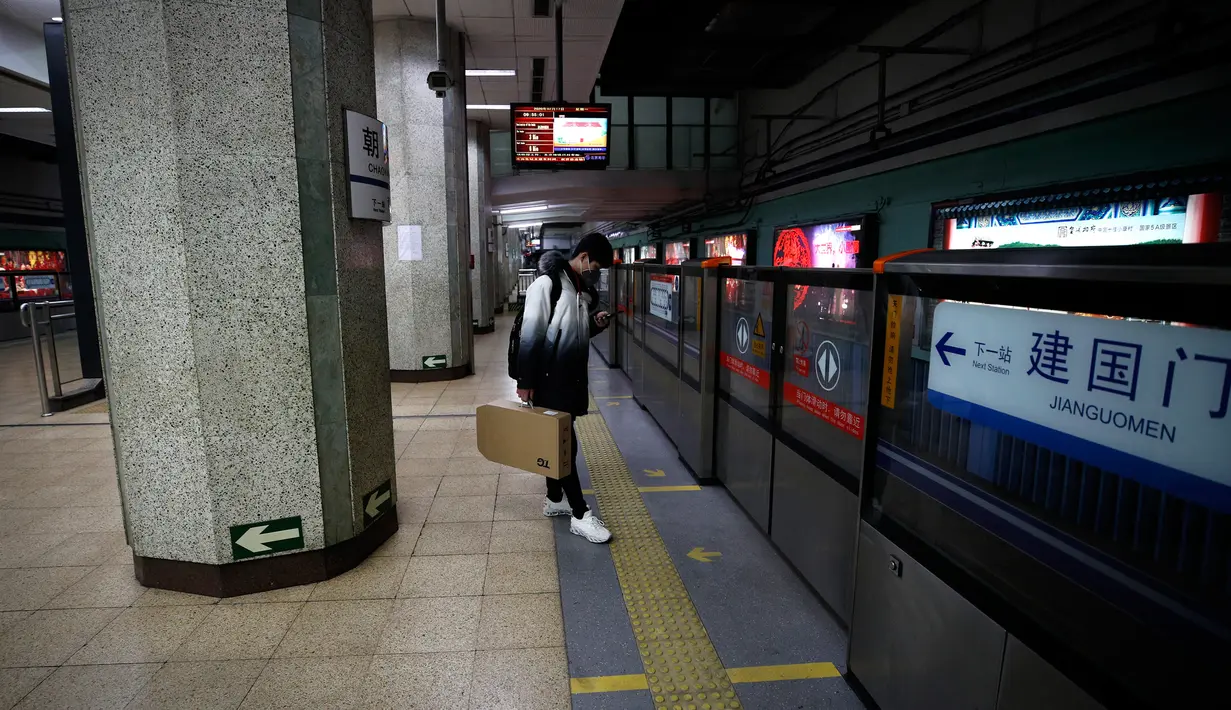 Seorang pria mengenakan masker saat berdiri sendirian menunggu kereta di stasiun bawah tanah di Beijing, China, Senin (17/2/2020). Kendati berjarak 1.055 kilometer dari Wuhan yang dikarantina akibat virus corona atau COVID-19, aktivitas warga di Beijing terlihat sepi. (AP Photo/Andy Wong)