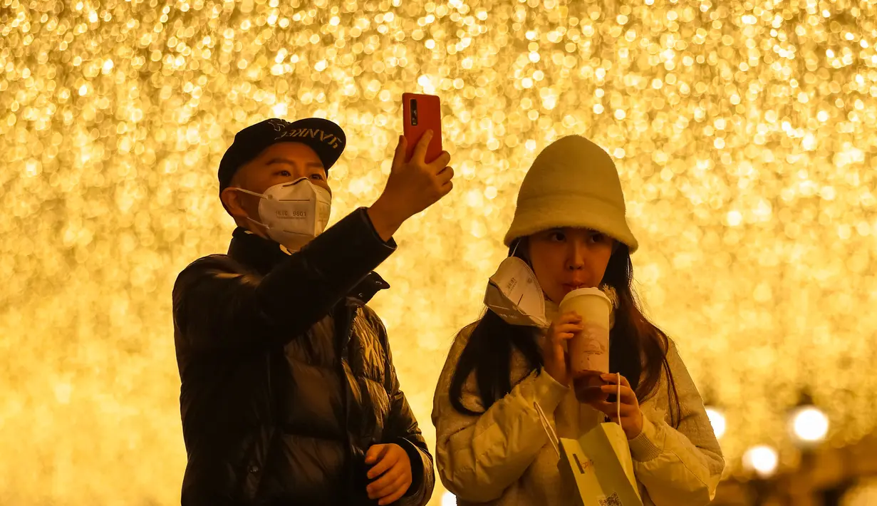 Orang-orang berhenti sejenak di sebuah jalan kawasan perniagaan di Wuhan, Provinsi Hubei, China tengah, pada 30 Maret 2020. Jalan-jalan kawasan perniagaan di Wuhan kembali ramai seiring meredanya wabah COVID-19. (Xinhua/Shen Bohan)