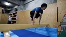 Juni Sato mengawasi anak didiknya saat latihan parkour diatas matras di sebuah di gym di Tokyo, Jepang (23/10). Karena cintanya dengan seni olahraga ekstrem ini, Sato mendirikan sekolah parkour yang diberi nama SENDAI X-TRAIN. (Reuters/Kim Kyung-Hoon)