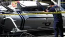 Seorang petugas mengambil gambar helikopter bell 429 yang membawa kepala polisi Filipina setelah jatuh di San Pedro, selatan Manila, Kamis (5/3/2020). Gangguan visibilitas menyebabkan helikopter menabrak kabel listrik dan kemudian jatuh. (AP/Aaron Favila)