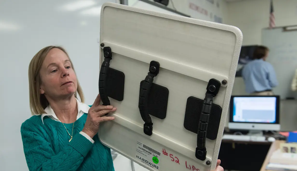 Guru matematika Worcester Prep Linda Bragg menunjukkan papan tulis anti peluru Hardwire di kelas di Berlin, Maryland, (1/3). Papan seberat 1,5 kg juga bisa berfungsi sebagai tameng untuk menyelamatkan nyawa murid-muridnya. (AFP PHOTO / Nicholas Kamm)