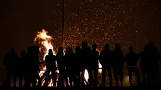 Sejumlah orang mengikuti tradisi malam San Juan's (Saint John) di Gijon, Spanyol, (24/6). Malam San Juan adalah upacara penyucian dimana warga membakar sejumlah benda yang sudah tidak diinginkan. (REUTERS/Eloy Alonso)