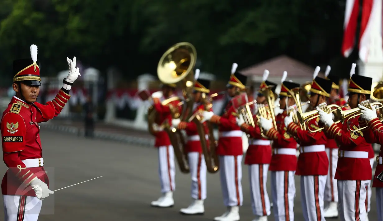 Aksi marching band Paspampres memainkan alat musik trompet dan baritone horn di halaman luar Istana Merdeka, Jakarta, Minggu (28/8). Pergantian pasukan jaga Istana Kepresidenan menjadi objek atraksi wisata baru bagi warga. (Liputan6.com/Faizal Fanani)