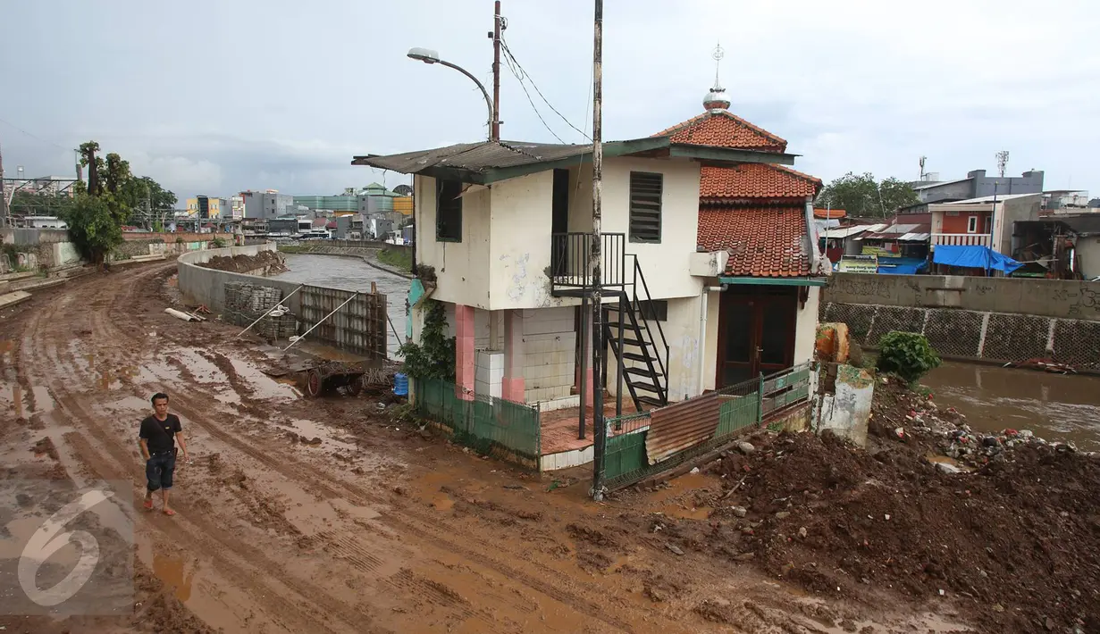 Warga melintas di dekat Mushala Assa'adah yang berada di bantaran Sungai Ciliwung, Jakarta, Kamis (2/2). Rencananya mushala ini akan segera dibongkar setelah pengerjaan bangunan mushala baru di kawasan tersebut selesai. (Liputan6.com/Immanuel Antonius)