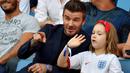 Legenda Timnas Inggris, David Beckham, bersama anak perempuannya, Harper Beckham, saat menyaksikan pertandingan antara Inggris melawan Norwegia pada laga Piala Dunia Wanita di Prancis, (27/6/2019). (Photo by LOIC VENANCE / AFP)