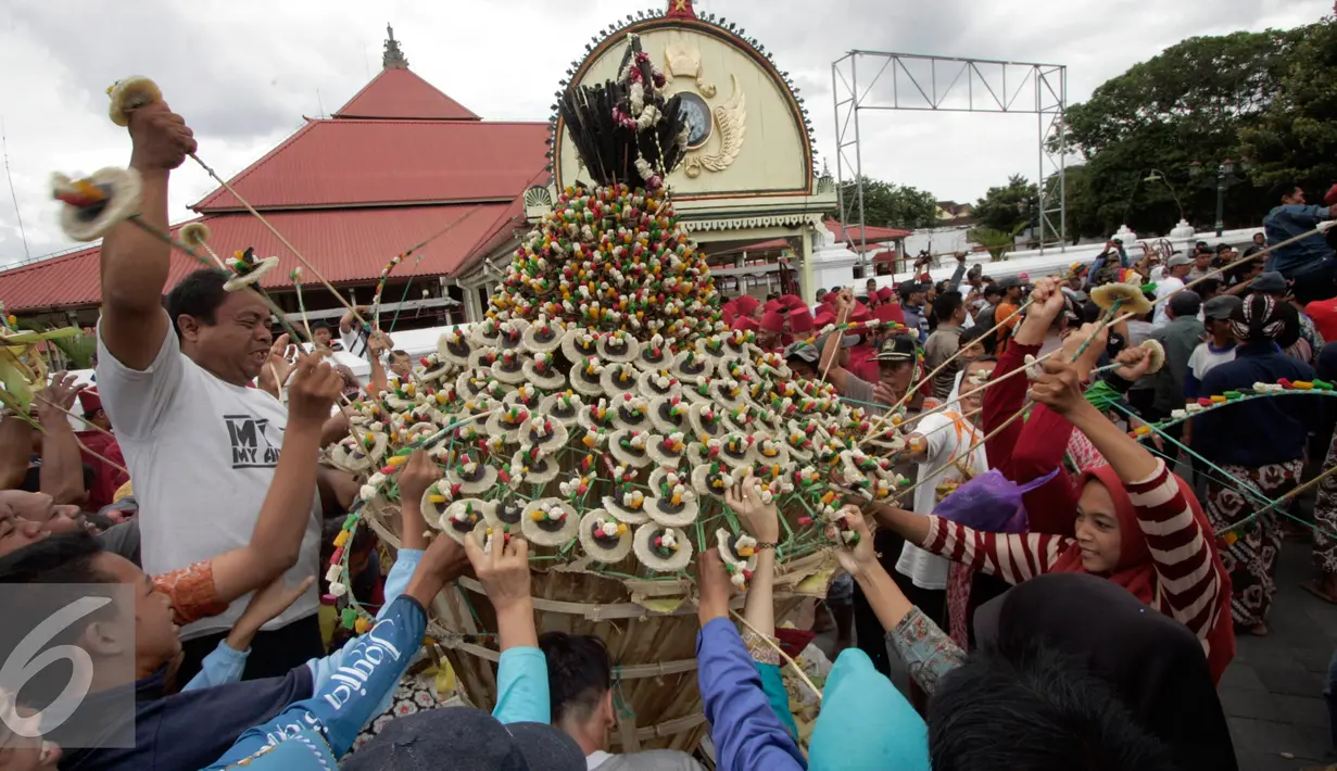 Warga berebut mengambil sesuatu di gunungan saat Grebeg Idul Adha, Yogyakarta, Selasa (13/9). Acara tahunan ini menjadi salah satu daya tarik kota Yogyakarta. (Liputan6.com/Boy Harjanto)