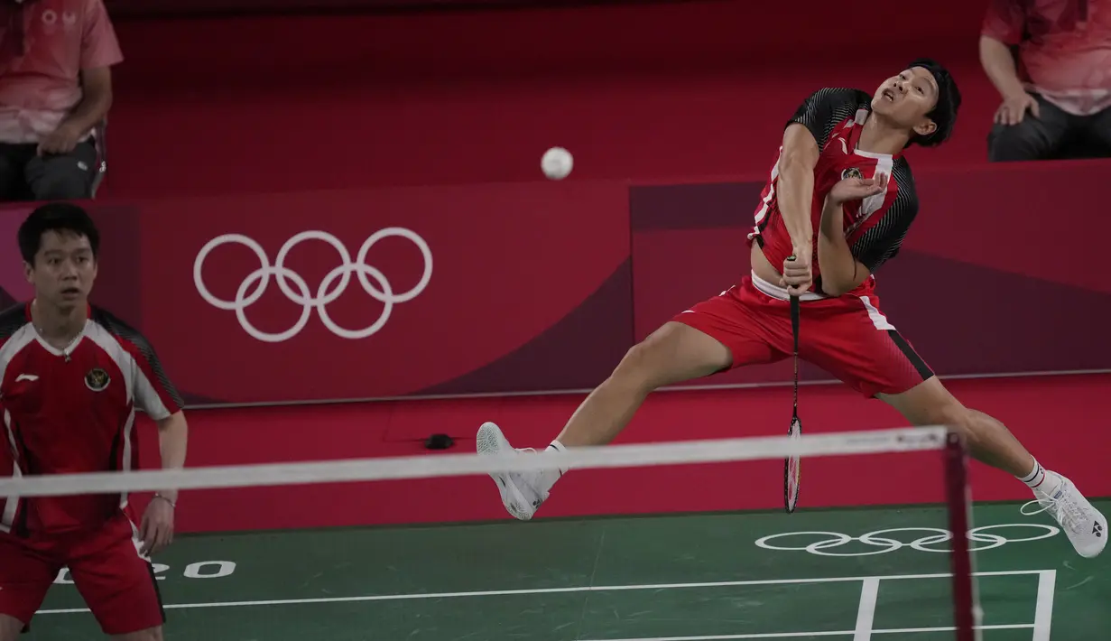 Ganda putra Indonesia Marcus Gideon (kanan) dan Kevin Sanjaya Sukamuljo bersaing dengan Ben Lane dan Sean Vendy dari Inggris pada pertandingan ganda putra Grup A Olimpiade Tokyo  2020 di Musashino Forest Sports Plaza, Sabtu (24/7/2021). Kevin / Marcus menang 21-15, 21-11 (AP Photo/Dita Alangkara)