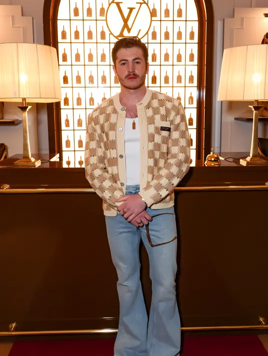 Kieron Moore bergaya chic dengan gaya retro memadukan shirt, cardigan, dan cut bray denim pants [Louis Vuitton]