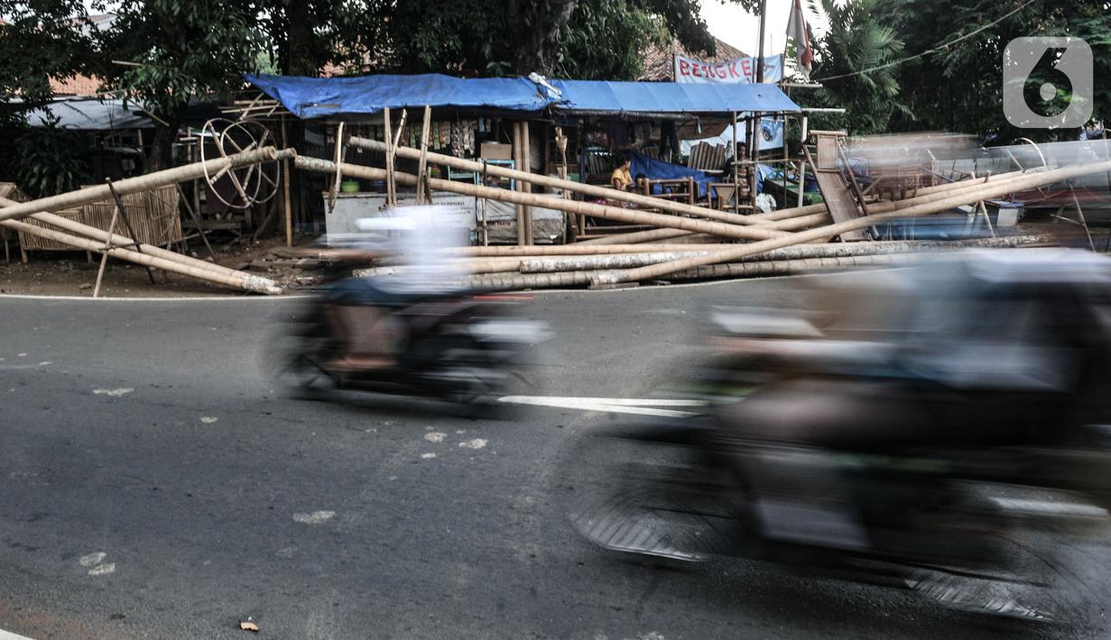 Kendaraan melintas di depan tumpukkan pohon pinang yang dijual di Jalan Manggarai Utara, Jakarta, Selasa (11/8/2020). Penjualan pohon pinang tahun ini menurun drastis dibandingkan tahun sebelumnya akibat pandemi Covid-19 yang menyebabkan larangan sejumlah perlombaan. (merdeka.com/Iqbal Nugroho)
